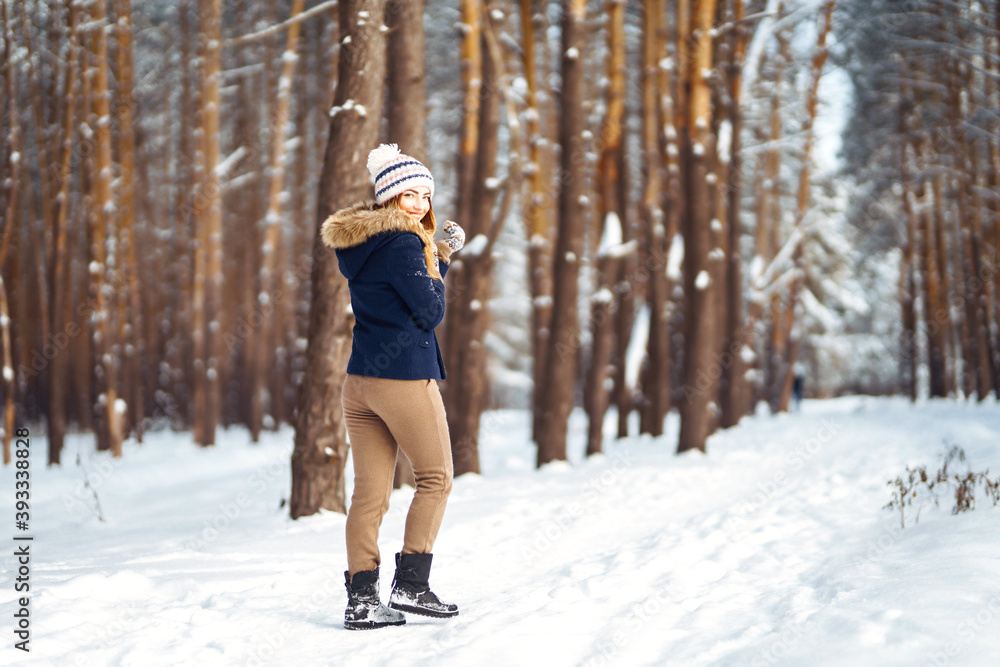 Portrait of Beautiful woman enjoys winter, frosty day. Fashion young woman in the snow forest. Winter holidays.