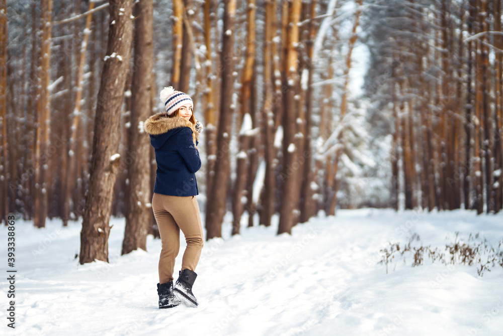 Portrait of Beautiful woman enjoys winter, frosty day. Fashion young woman in the snow forest. Winter holidays.