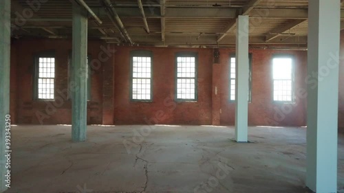 Interior view of an empty, unfinished office space that is under construction inside a large brick building. photo