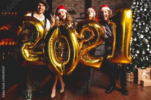 Party, people and new year holidays concept - women and men celebrating new years eve 2021