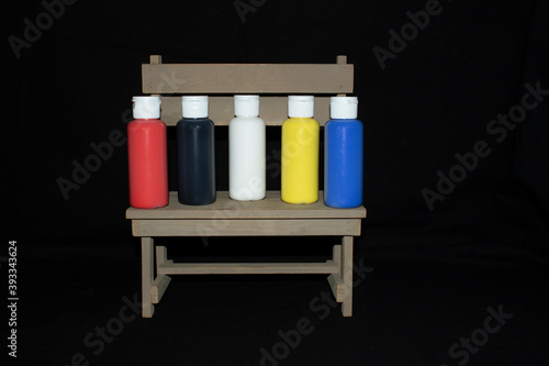 five primary colors of acrylic paint on a bench