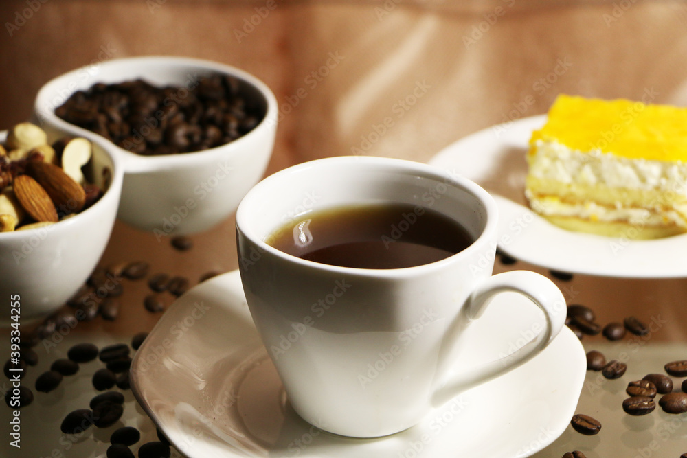 Cup of coffee and coffee beans on a glass table. The concept of home comfort and warmth. Cup of coffee and coffee beans on a glass table. The concept of home comfort and warmth.