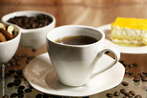 Cup of coffee and coffee beans on a glass table. The concept of home comfort and warmth.