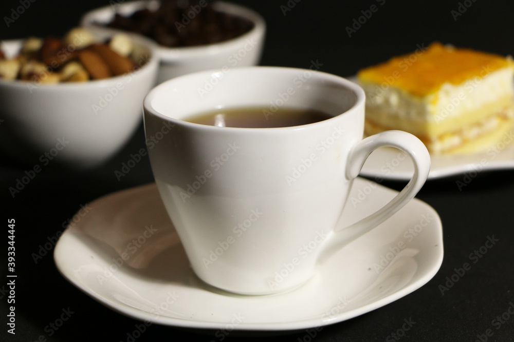 A cup of coffee with milk and coffee beans on a glass table. The concept of home comfort and warmth. A cup of coffee with milk and coffee beans on a glass table. The concept of home comfort and warmth.