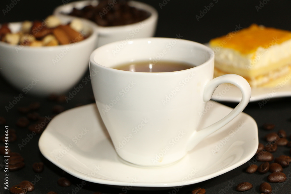 A cup of coffee with milk and coffee beans on a glass table. The concept of home comfort and warmth. A cup of coffee with milk and coffee beans on a glass table. The concept of home comfort and warmth.