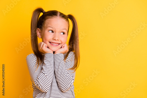 Portrait of young cute adorable smiling girl child kid hold hands under chin isolated on yellow color background