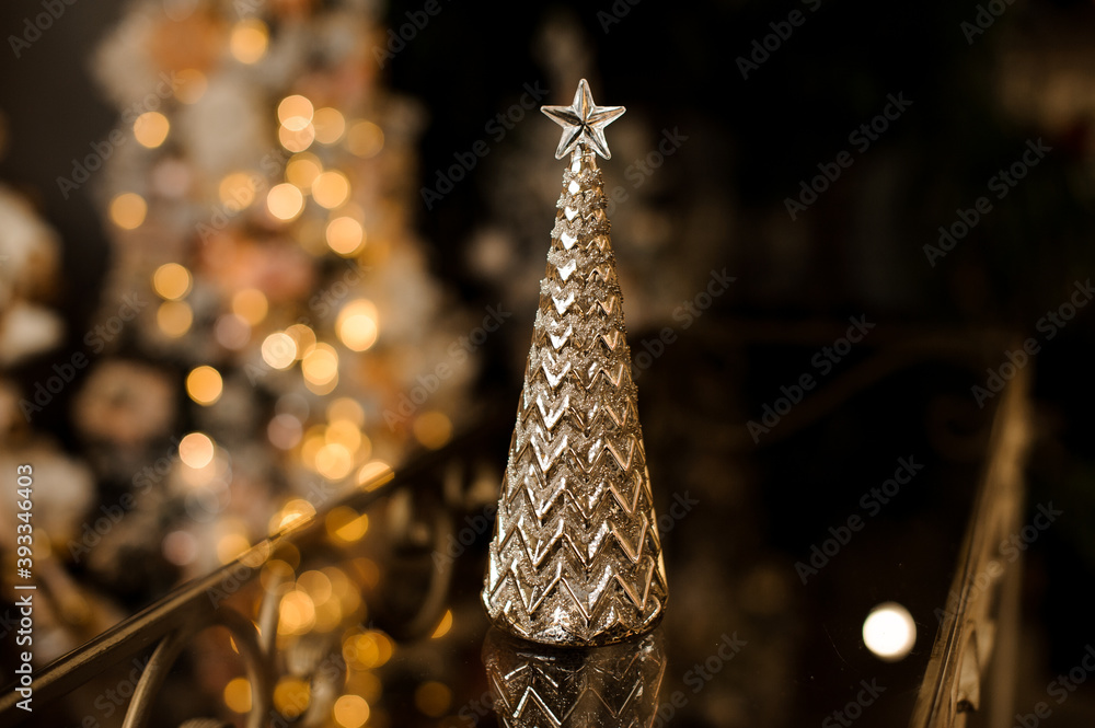 Gorgeous figurine in the form of golden Christmas tree stands on the table