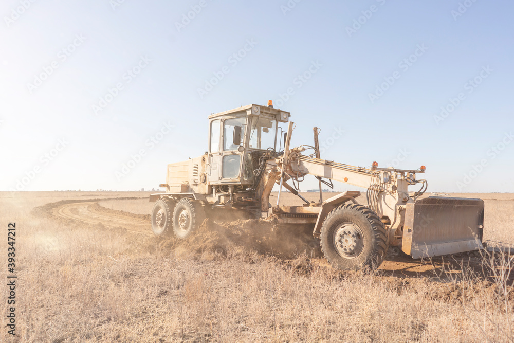 grader machine making a new road, dig the gravel dirt in the field grader machine making a new road, dig the gravel dirt in the field