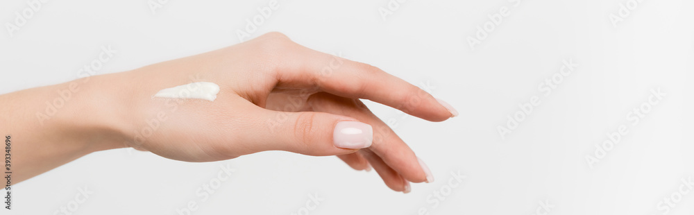 partial view of woman with cosmetic cream on hand isolated on white, banner partial view of woman with cosmetic cream on hand isolated on white, banner