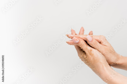 cropped view of woman applying scrub on hands isolated on white