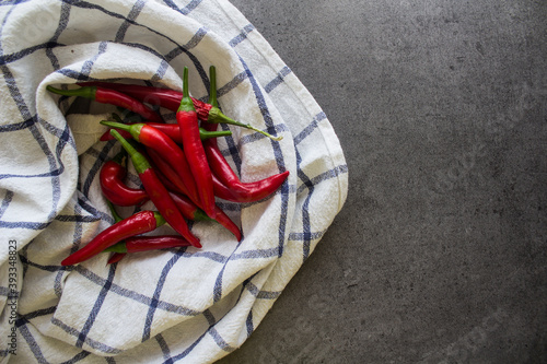 Red chili peppers on blue and white towel. Fresh vegetables top view photo. Cayenne pepper texture close up.  