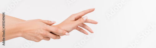 partial view of woman touching hand while applying hand cream isolated on white  banner