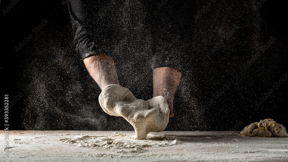 Fototapeta premium chef prepares the dough with flour to make pasta. Pizza dough. Cooking bread. Kneading the Dough. the concept of nature, Italy, food, diet and bio
