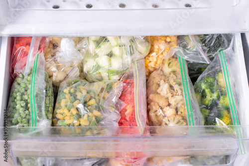 Valokuva Plastic bags with deep frozen vegetables in refrigerator