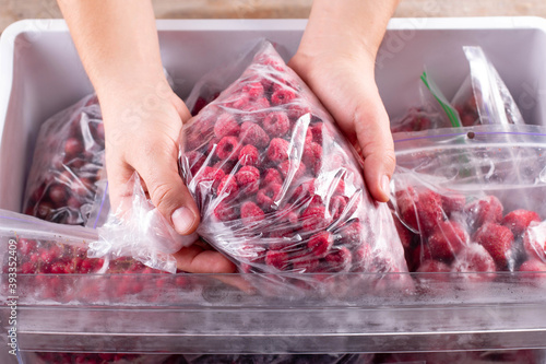 Fototapeta Naklejka Na Ścianę i Meble -  Frozen raspberries. Frozen berries and fruits in a plastic bag in refrigerator