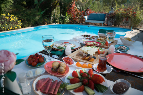 A healthy and delicious breakfast with local organic and natural foods on a white table by the pool at the hotel. food and drink holiday concept