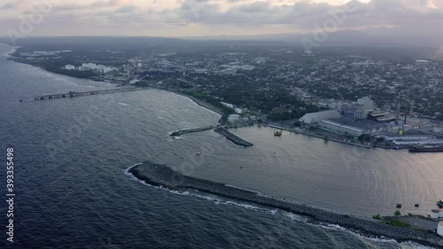 Haina port and sunbeams over city in background, Dominican Republic. Aerial photo