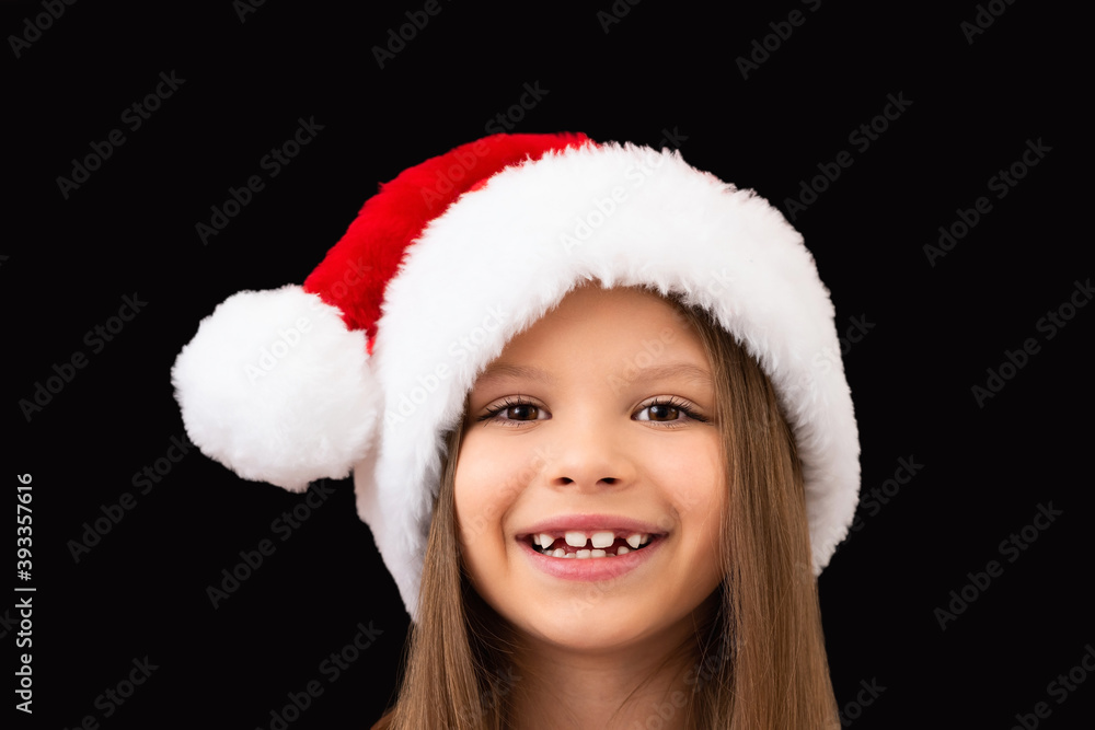 A beautiful girl smiles in a Christmas hat. A beautiful girl smiles in a Christmas hat.