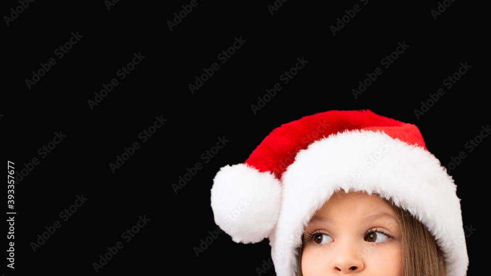 A child in a Christmas hat looks out. A child in a Christmas hat looks out.
