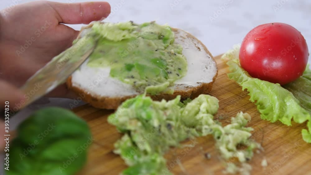 Spreading Mashed Avocado On a Toast. Healthy Vegan Breakfast. Cooking healthy food Spreading Mashed Avocado On a Toast. Healthy Vegan Breakfast. Cooking healthy food
