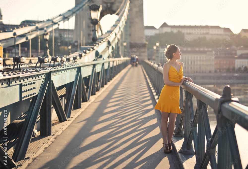 Fototapeta premium young woman walks on the chain bridge in budapest