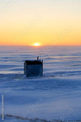 Ice fishing at sunset along the shores of Prince Edward Island, Canada. photo