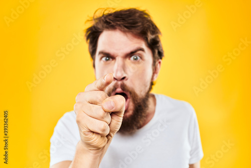 bearded man gesturing with hands studio lifestyle discontent yellow background