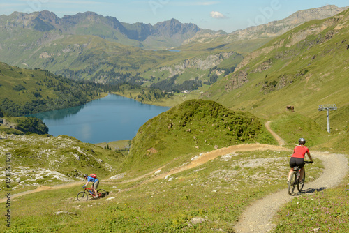 People on mountain bike going down the flow track from Jochpass over Engelberg in the Swiss Alps