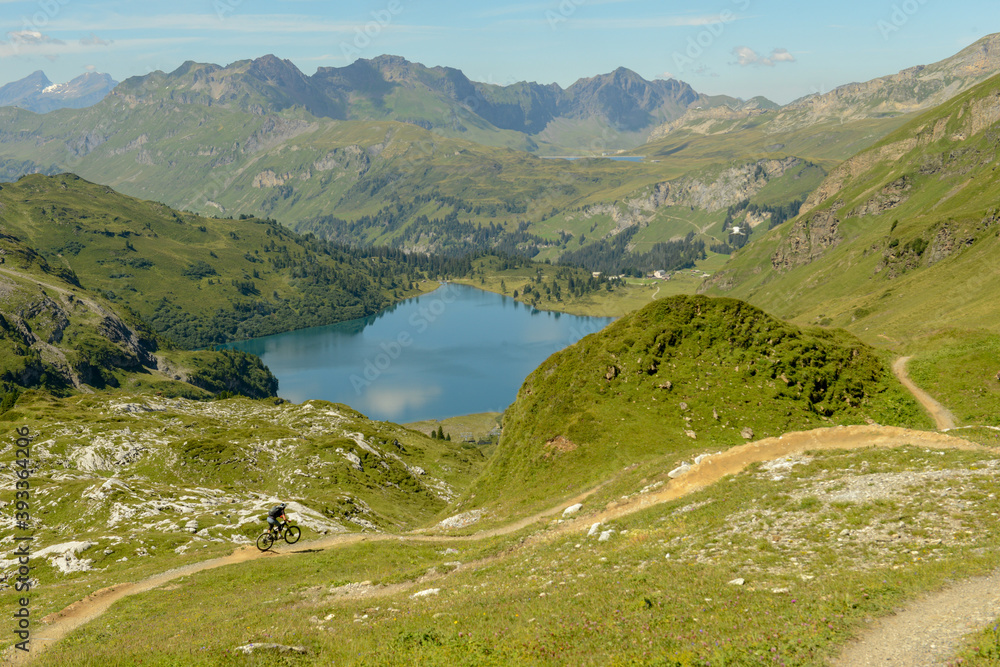 People on mountain bike going down the flow track from Jochpass over Engelberg in the Swiss Alps People on mountain bike going down the flow track from Jochpass over Engelberg in the Swiss Alps