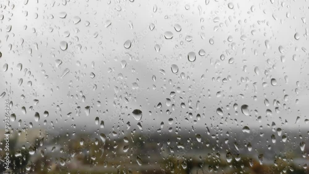 Raindrops on the window, abstract background. Dull rainy day and rain drops on window glass on gloomy autumn day on blur background closeup Raindrops on the window, abstract background. Dull rainy day and rain drops on window glass on gloomy autumn day on blur background closeup