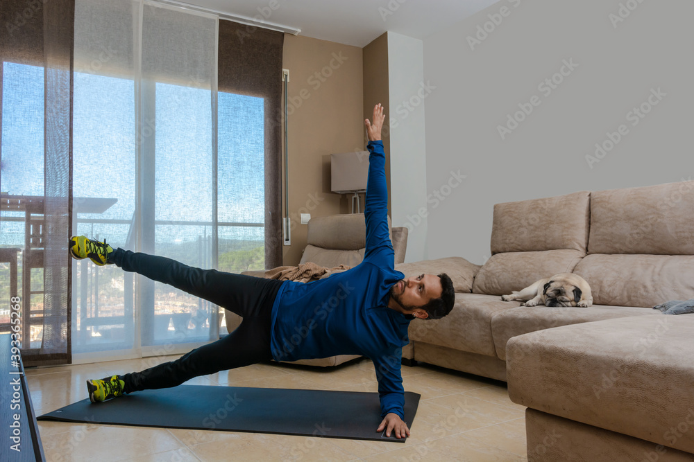 Latin man, doing a workout in his living room.