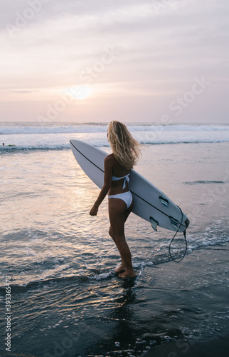 Unrecognizable female surfer with surfboard