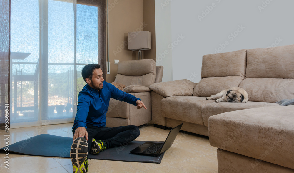 Latin man, doing a workout in his living room with a rubber band