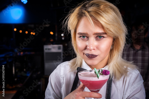 Girl barman makes a cocktail on the alehouse photo