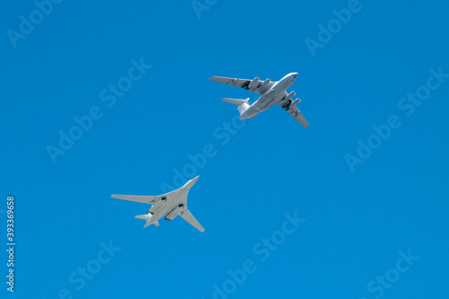 Two military aircraft refuel in the sky