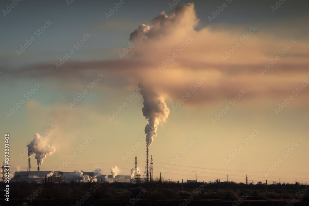Many factory chimneys with clouds of smoke