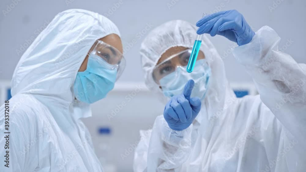 African american scientist holding test tube and talking with colleague African american scientist holding test tube and talking with colleague