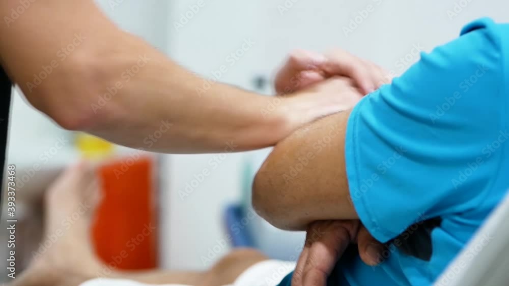 Anonymous male therapist massaging arm of crop patient Anonymous male therapist massaging arm of crop patient