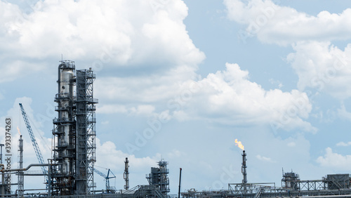 Distillation tower or column on blue sky with clouds background. Oil refinery plant. Refining complex. Petrochemical industry concept.