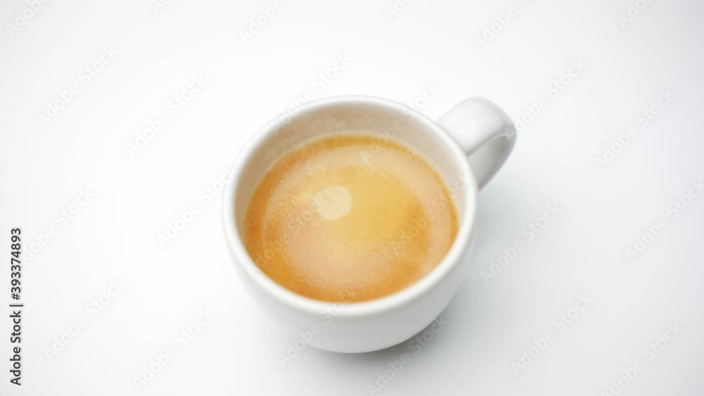 White cup of espresso coffee rotating on a white background in a cafe for breakfast or a break. White cup of espresso coffee rotating on a white background in a cafe for breakfast or a break.