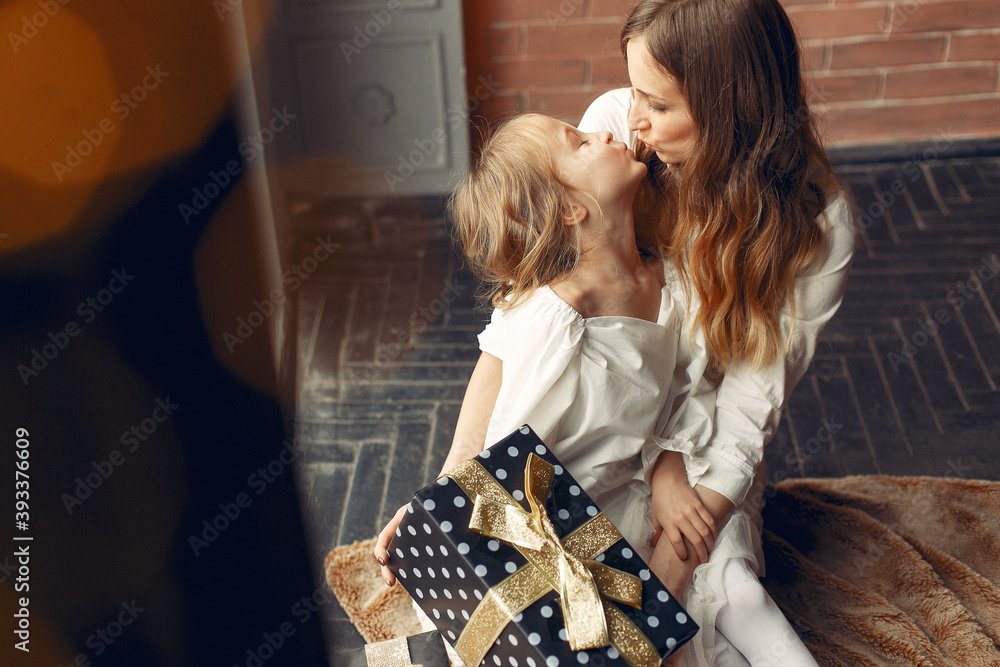 Beautiful mother in a white dress. Family with cristmas gifts. Girls near window. Beautiful mother in a white dress. Family with cristmas gifts. Girls near window.