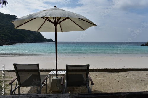 beach chairs and white umbrella on the  white sand beach and blue sky and sea phuket thailand
