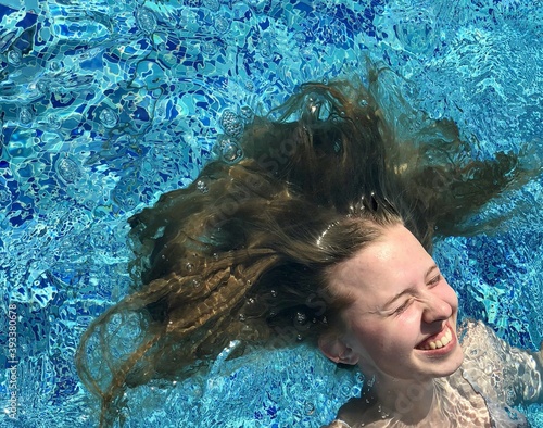 girl's hair floating in the water. Girl floating and smiling