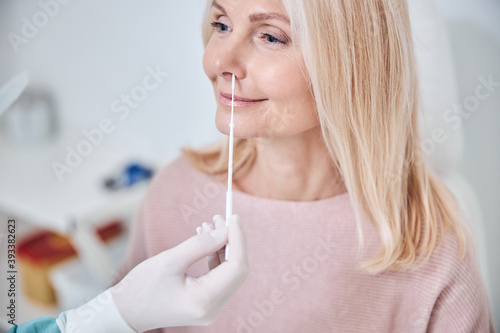 Smiling female patient undergoing a medical procedure