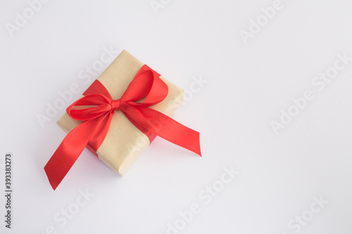 Closeup on gift with red ribbon on the white background with copy space