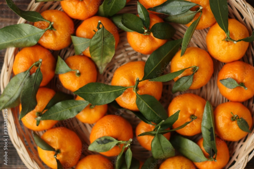 Juicy tangerines with green leaves on a wooden table 