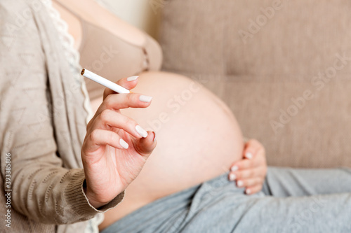 Pregnant woman with cigarette at home. mother smoking concept