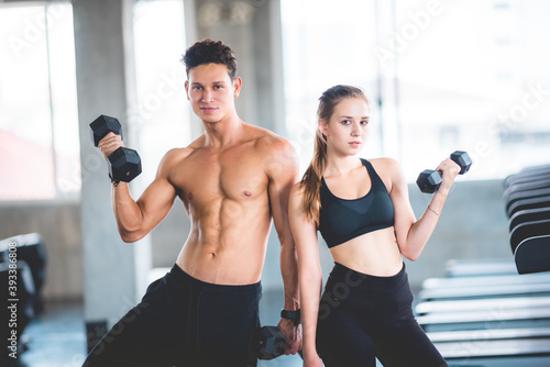 beautiful girl and her well-built boyfriend trainer, They are happy to see each othr in the gym. Young people are ready to start their workout