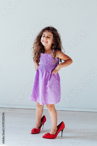 Wallpaper Mural Beautiful little curly fashionable girl in mom's shoes Torontodigital.ca