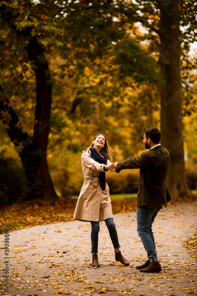 Fototapeta premium Young couple having fun in the autumn park
